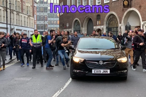 a group of people walking around a black car innocams